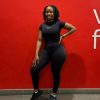 Full length mirror selfie of Mint Athleisure Essence two-piece set in black. Standard in front of Virgin Active gym wall
